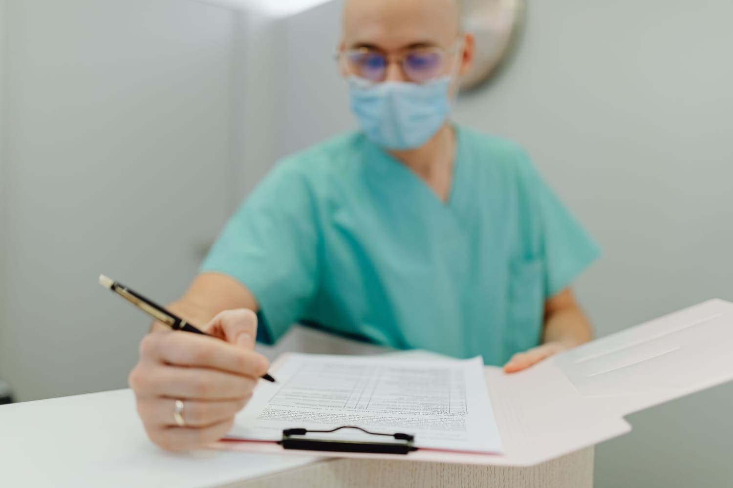 Registered manager completing a CQC compliance audit checklist on a clipboard